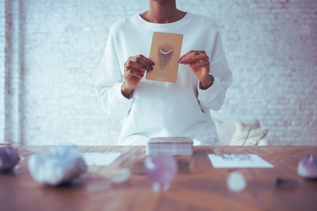Mujer sosteniendo una carta de tarot